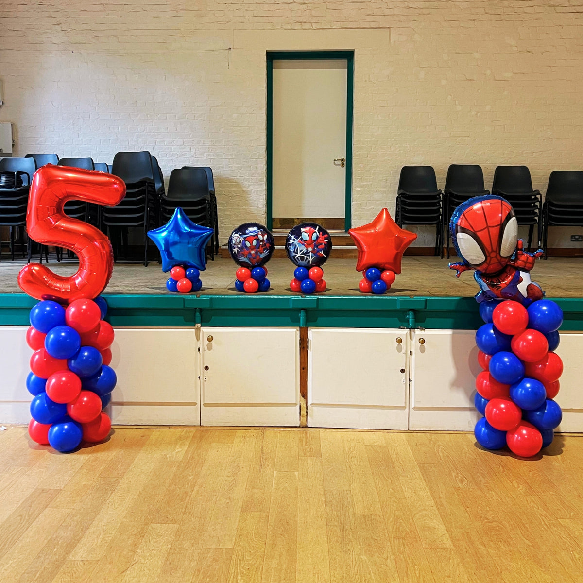 Royal Blue & Red Spiral Balloon Towers with Giant Red '5' and Spiderman Supershape on top. Royal Blue & Red Foil Stars and 18" Spiderman Foils on Air-Filled Latex Bases