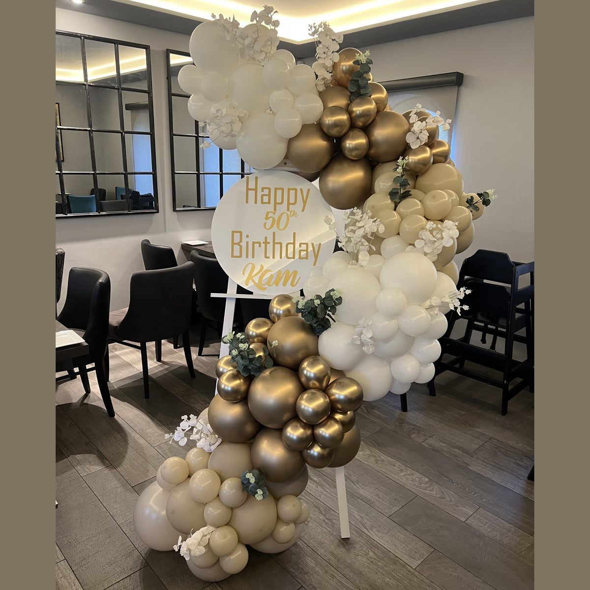 Easel Display Board with Personalised Vinyl Print and Gold Chrome, White Sand & White Balloon Garland with Green & White Foliage detail
